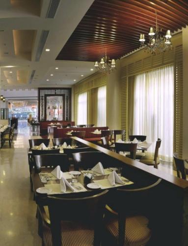 a dining room with tables and chairs in a restaurant at Park Inn Gurgaon in Gurgaon