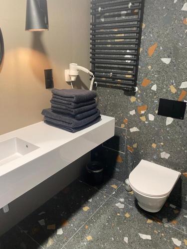 a bathroom with a toilet and a sink with towels at Apartament Złota Perła Czarna Góra in Sienna