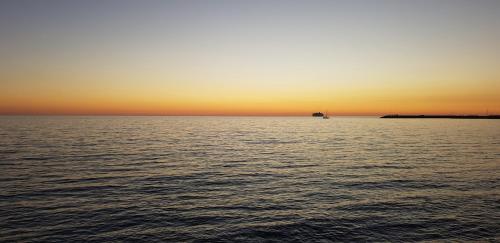 a sunset over a large body of water at B&B Le Dune Beach in San Leone