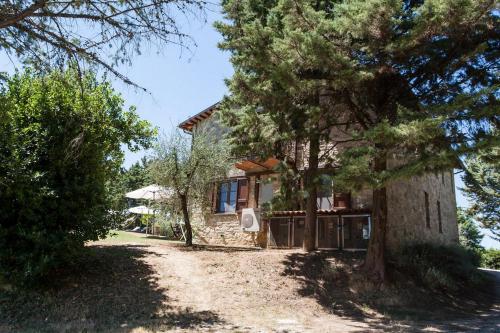a stone house with trees in front of it at Podere Caldaruccio La Pineta in Bosco