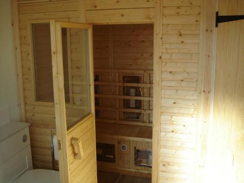 een kleine kamer met een houten muur in een hut bij Kwerky Cottage in North Lydbury