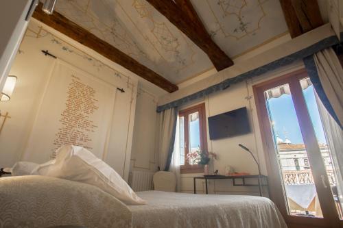 a bedroom with a bed and a window at Hotel Antigo Trovatore in Venice