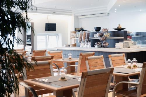 un restaurant avec des tables et des chaises en bois et un comptoir dans l'établissement Hotel Chambord, à Bruxelles