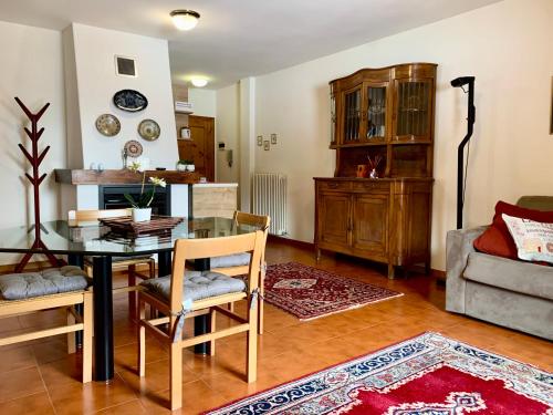 uma sala de estar com uma mesa de vidro e cadeiras em Cima de’ Piazzi Apartment em Isolaccia