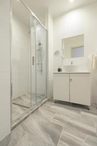 a bathroom with a glass shower and a sink at Ponty-Lak Panzió in Dávod
