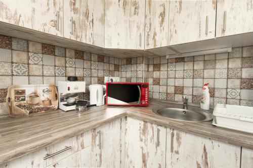 a kitchen counter with a microwave and a sink at Ponty-Lak Panzió in Dávod