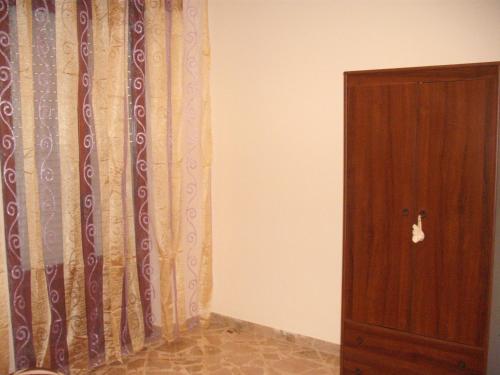 um quarto com uma cortina e uma porta de madeira em Calatafimi Segesta - Appartamento Garibaldi em Calatafimi