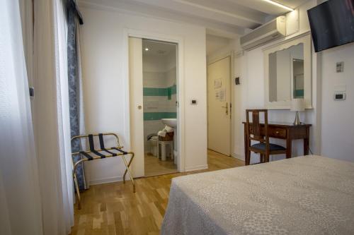 a room with a bed and a table and chairs at Hotel Antigo Trovatore in Venice