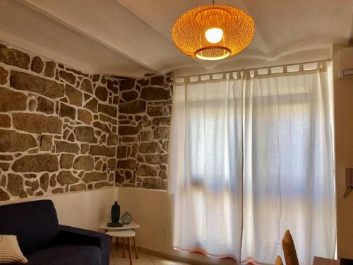 - un salon avec une fenêtre et un mur en pierre dans l'établissement Il Gabbiano case vacanza, à Santa Teresa Gallura