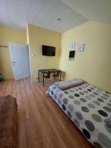 a bedroom with a bed and a table with a television at Pasile in Kaunas