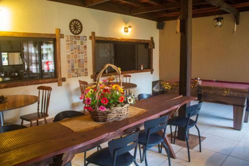 a dining room with a table with a basket of flowers at Pousada Caliandra Da Serra in Canela