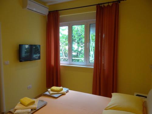 1 dormitorio con 1 cama, ventana y toallas en Rooms Stella en Split