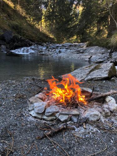 a camp fire on the rocks near a river at Ferienwohnung Stenna SELVA direkt bei Bergbahnen Skipiste in Flims