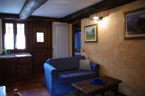 VilladossolaにあるErebia Appartamenti Vacanzaのリビングルーム(青い椅子、テーブル付)