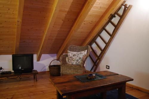 a living room with a table and a tv at Erebia Appartamenti Vacanza in Villadossola