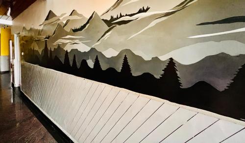 a mural of mountains on a wall in a hallway at JC Woodville Manor in Kodaikānāl