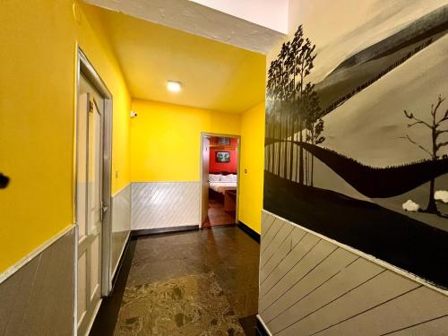 a hallway with yellow walls and a painting on the wall at JC Woodville Manor in Kodaikānāl