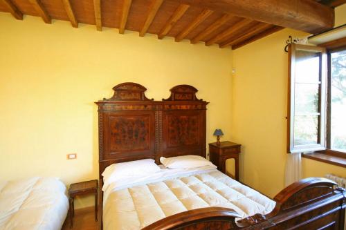 a bedroom with a bed with a wooden headboard at Podere Caldaruccio La Pineta in Bosco