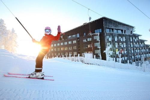 a person riding skis down a snow covered slope at Hotel Levi Panorama & Levi Chalets in Levi
