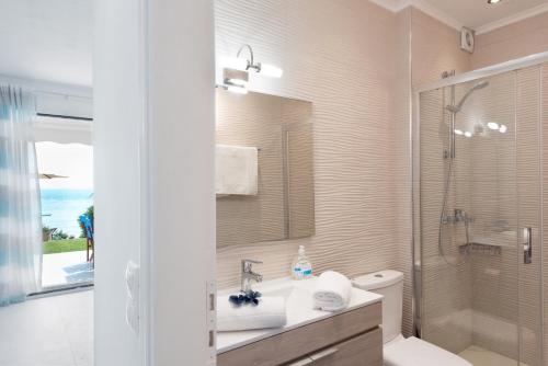 Un baño con inodoro, lavabo y ducha. en Waves Apartments: Two Beachfront Apartments, en Glyfada