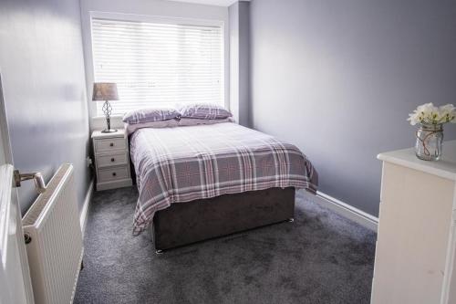 a small bedroom with a bed and a window at Tallets Apartment with Balcony & Parking in Tewkesbury