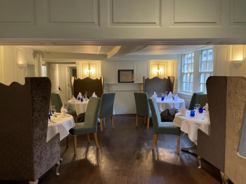 a dining room with white tables and chairs and tablesearcher at The Spread Eagle Hotel in Thame
