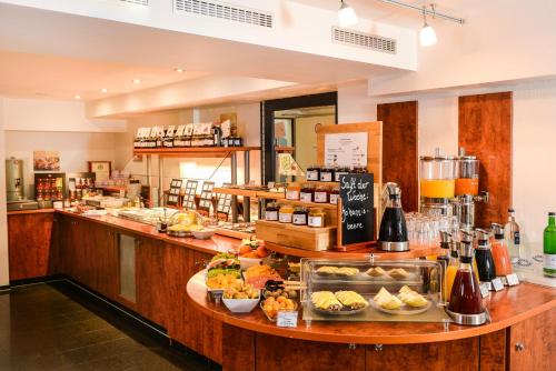 a restaurant with a counter with food on it at Hotel National Düsseldorf (Superior) in Düsseldorf