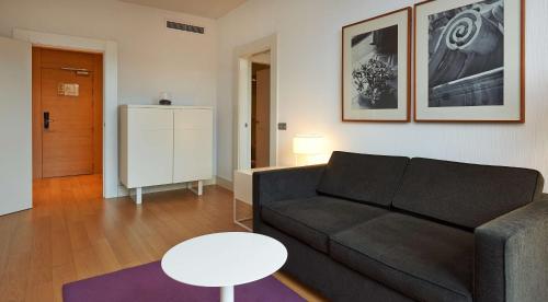 a living room with a couch and a table at NH Collection Villa de Bilbao in Bilbao