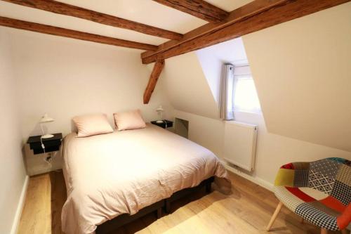 um pequeno quarto com uma cama e uma janela em Gîte Sainte Odile em Obernai