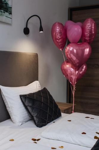 a bunch of pink balloons sitting on top of a bed at готель Тячів in Tyachiv