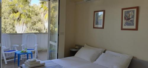 a bedroom with a white bed and a table and chairs at Le Barchette in San Cataldo