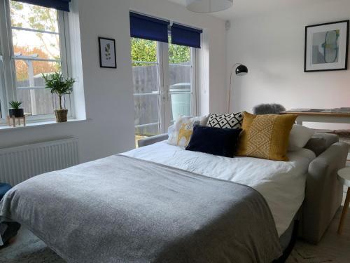 um quarto com uma cama com almofadas em Stylish & Spacious 3 Bed House With 2 Free Car Parking Spaces em Appledram