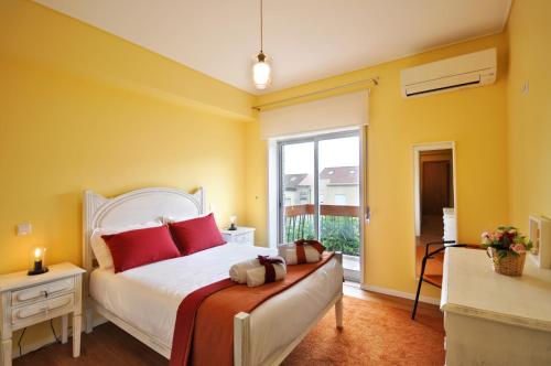 a bedroom with a bed with red pillows and a window at RH Charming Apartment Liberdade I in Braga