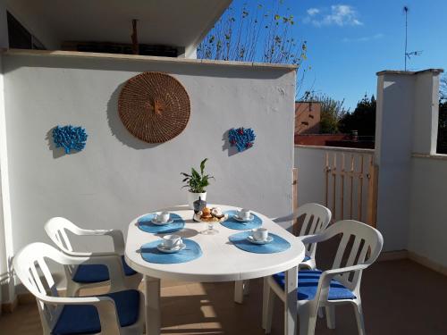 a white table and chairs on a white wall at Le Barchette in San Cataldo