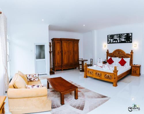a bedroom with a bed and a couch and a table at Lakegala Resort in Matale
