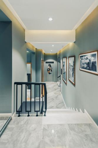 a hallway with blue walls and a staircase with a black rail at Eleven Hotel Baku in Baku