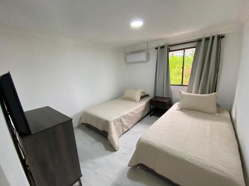 a room with two beds and a television in it at Posada Turistica el Swampito in San Andrés