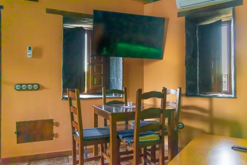una sala da pranzo con tavolo, sedie e TV di Casa en zona medieval a Monforte de Lemos