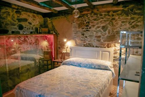 1 dormitorio con 2 camas y pared de piedra en Casa en zona medieval, en Monforte de Lemos