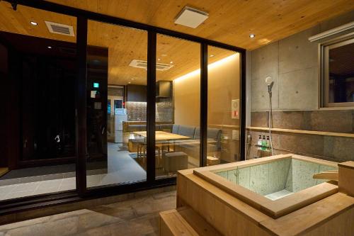 a bathroom with a tub and a table in a room at MATERIAL Fuchomae in Kyoto