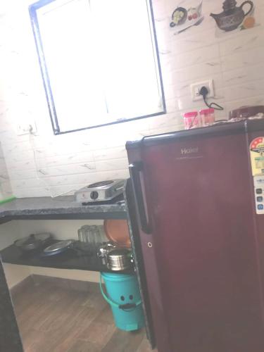 a small refrigerator in a kitchen with a window at BimalFarm at Koroli Hills in Igatpuri