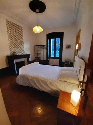 a bedroom with a large white bed in a room at Tulle Centre : grand et bel appartement in Tulle