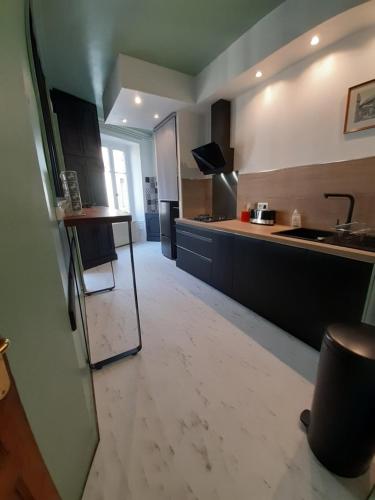 une cuisine avec un comptoir et une table à l'intérieur dans l'établissement Tulle Centre : grand et bel appartement, à Tulle