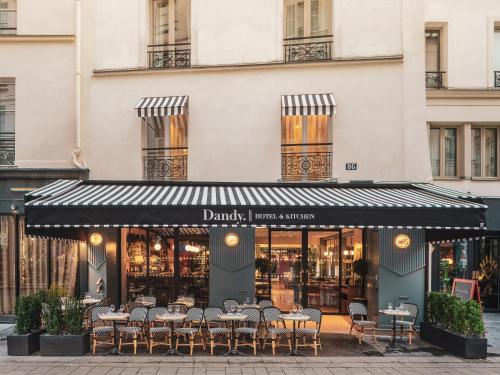 a restaurant with tables and chairs in front of a building at Dandy Hotel & Kitchen in Paris