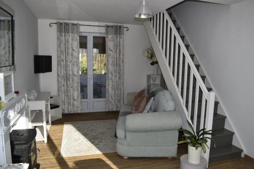a living room with a couch and a stair case at Gite Les Justices in Édon