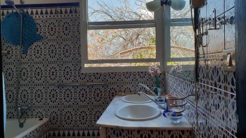 a bathroom with two sinks and a window at CASA FLORES in Los Llanos de Aridane
