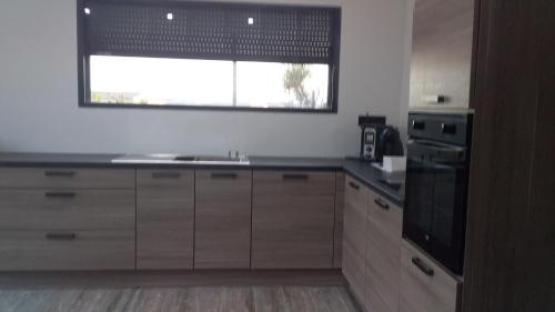 une cuisine avec un évier et une fenêtre dans l'établissement villa du jardin chez mandy, à Magalas