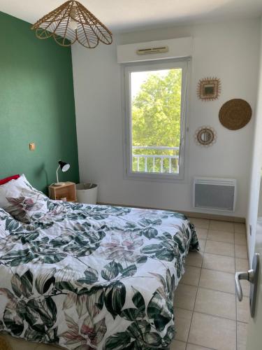 sypialnia z łóżkiem i oknem w obiekcie Appartement T2 avec balcon, lumineux, au calme. w mieście Blaye