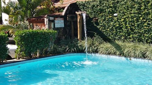 a swimming pool with a water fountain at Pousada do Abacateiro in Pirenópolis