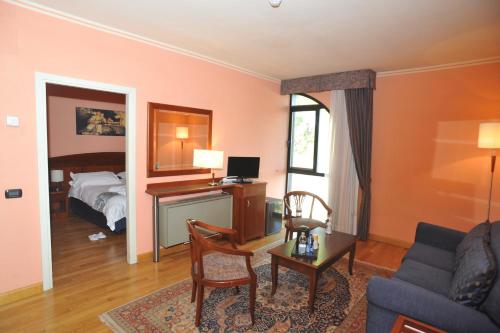 a living room with a bed and a desk at Hotel Hermitage in Poggio a Caiano